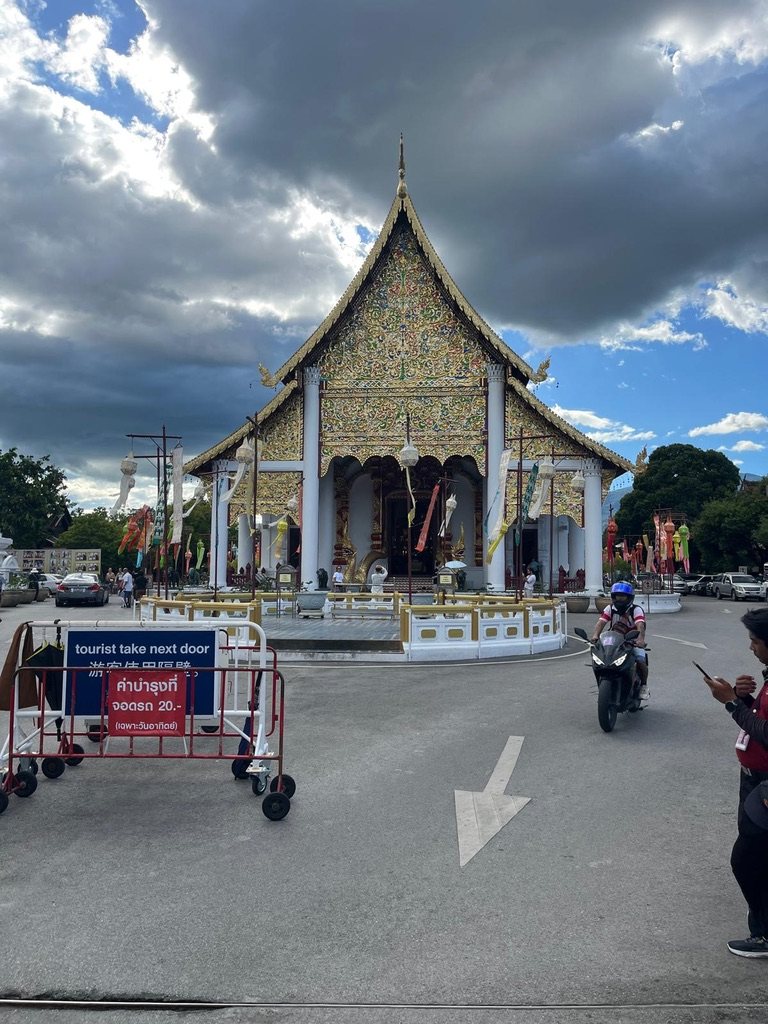 Golden Lanna-style temple under a cloudy sky