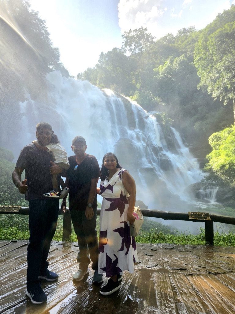 Family standing by a large waterfall