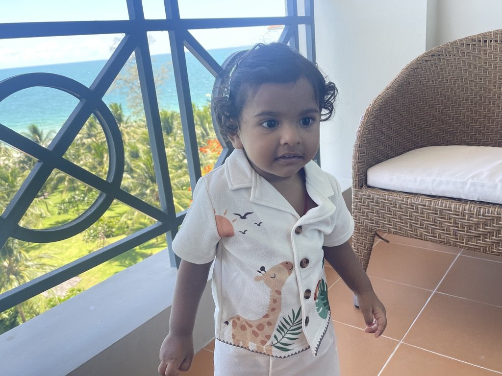 Toddler standing on a balcony with sea views