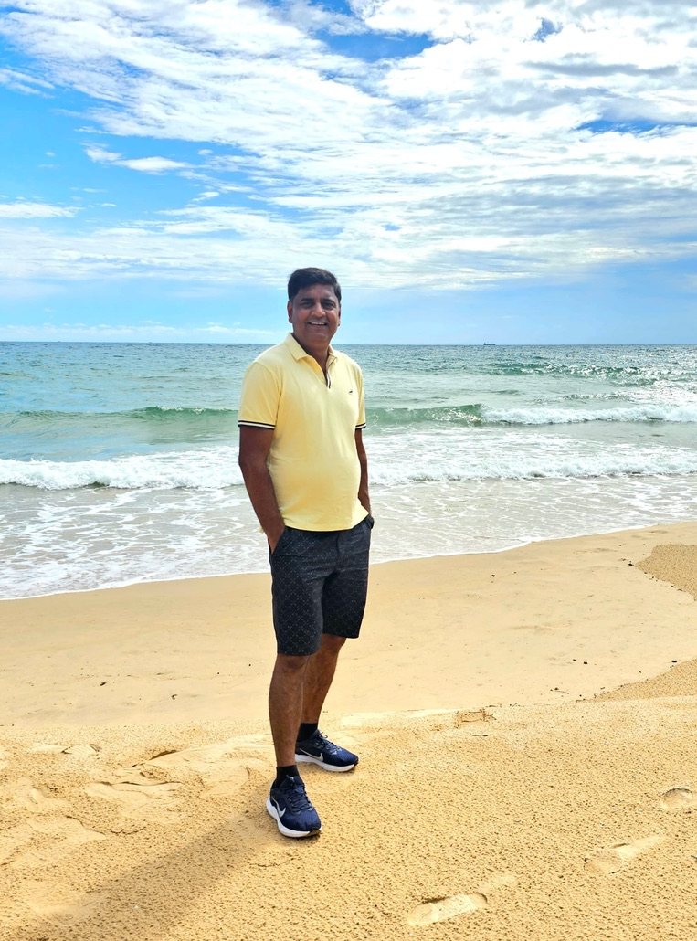 Man standing on a sandy beach with waves behind