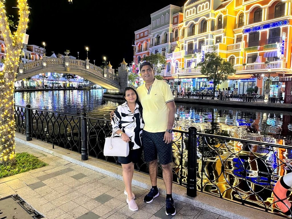 Couple standing by a canal with colourful buildings behind