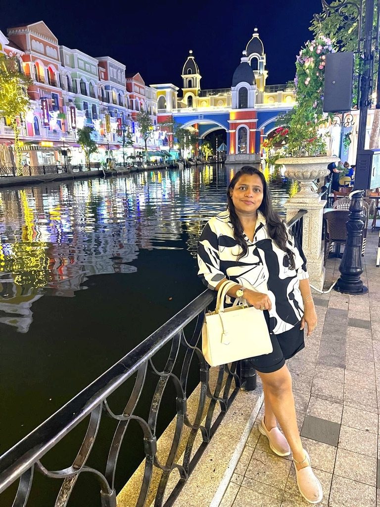 Woman by the railing of a canal at night