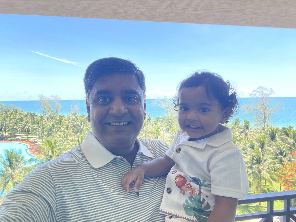 Father holding his young son on a balcony above the resort