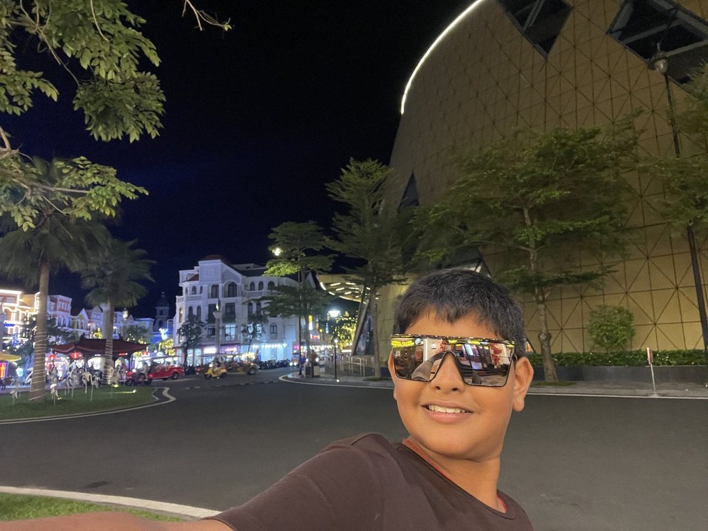 Boy in sunglasses taking a selfie at night