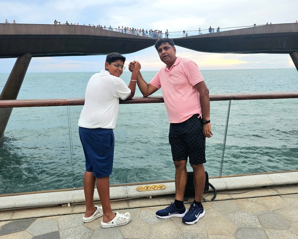 Father and son shaking hands at the bridge railing