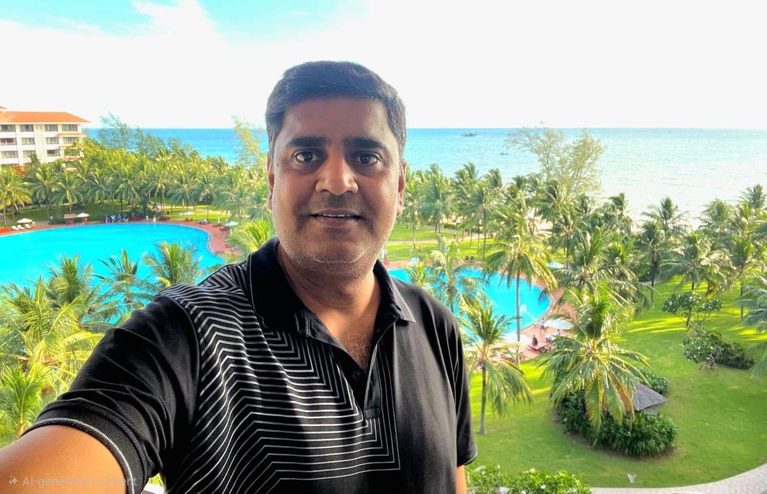 Selfie on a balcony above palm trees, pools and the sea