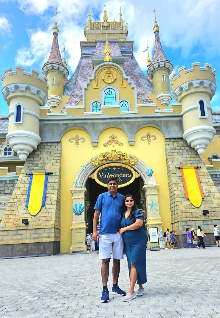 Couple standing in front of a fairytale castle gate